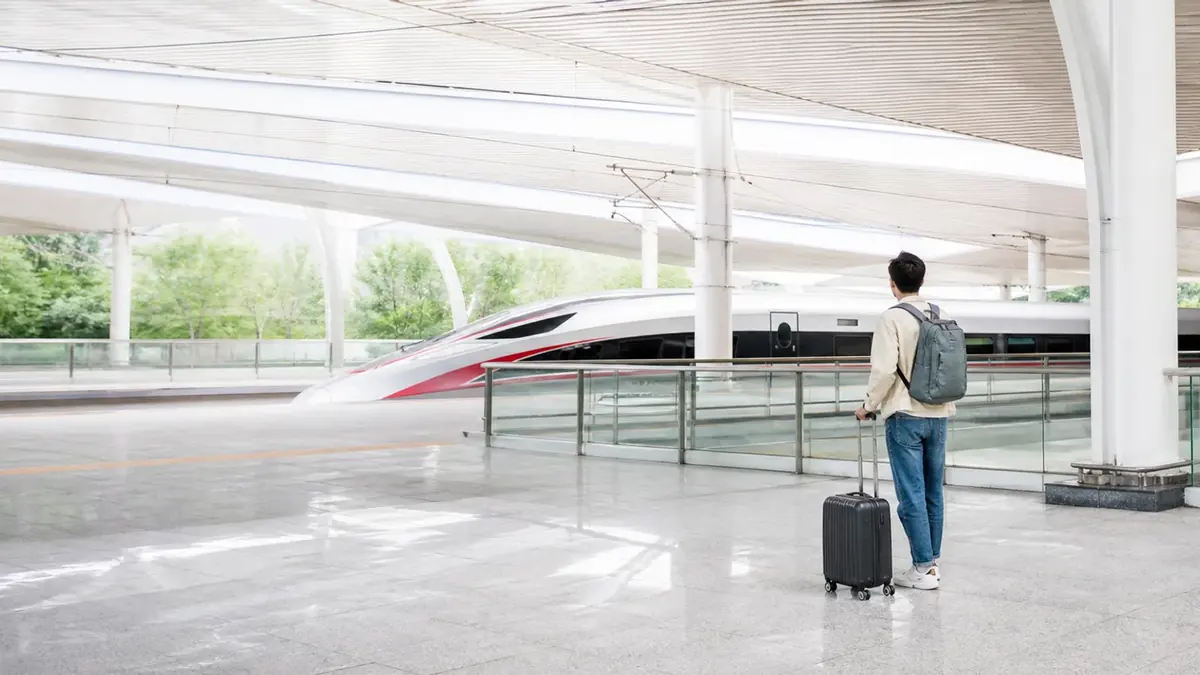 First-time traveler with luggage preparing to board a high-speed train at a railway station in China